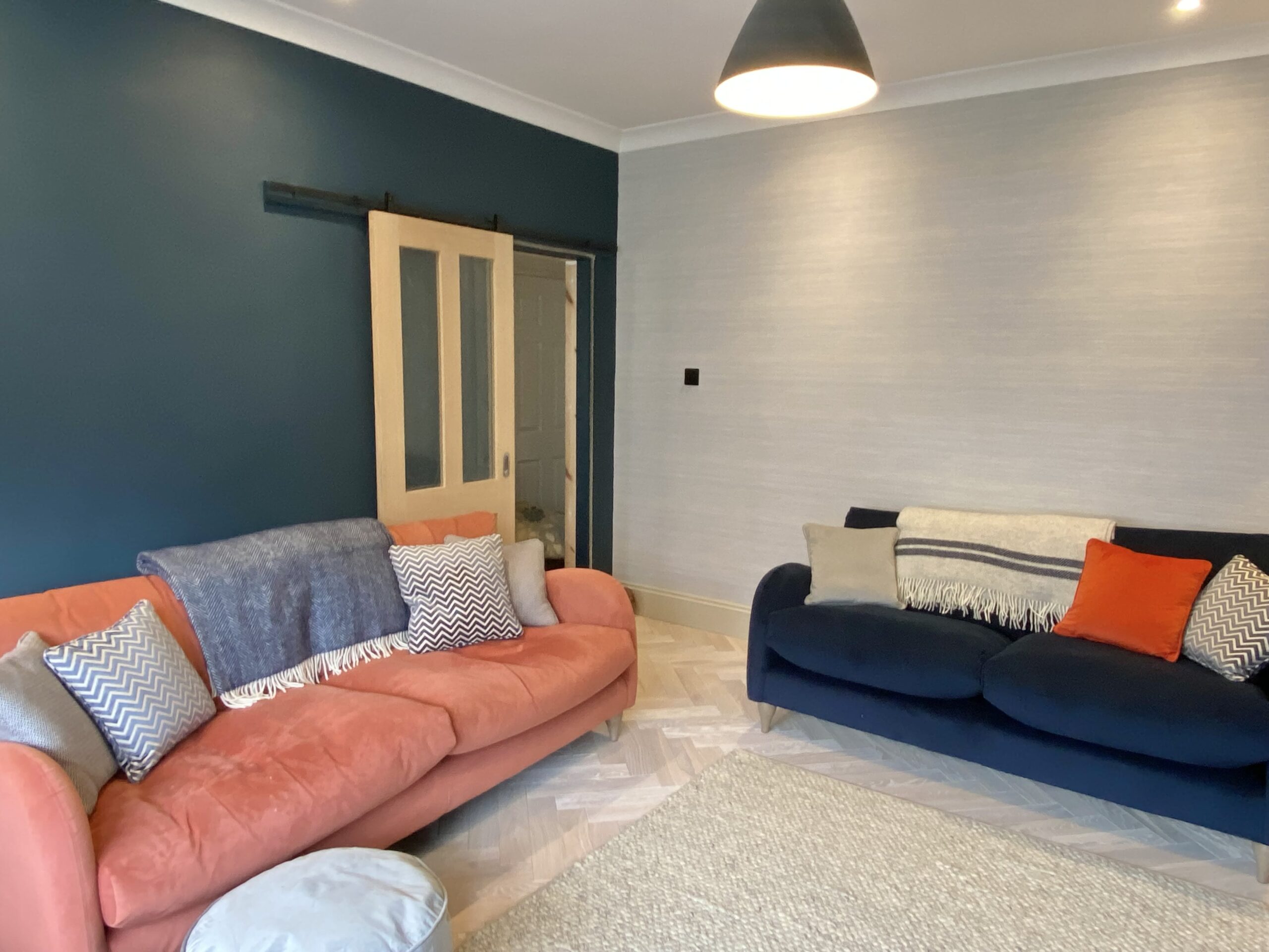 Orange and blue toned sitting room with a wooden door in the background 