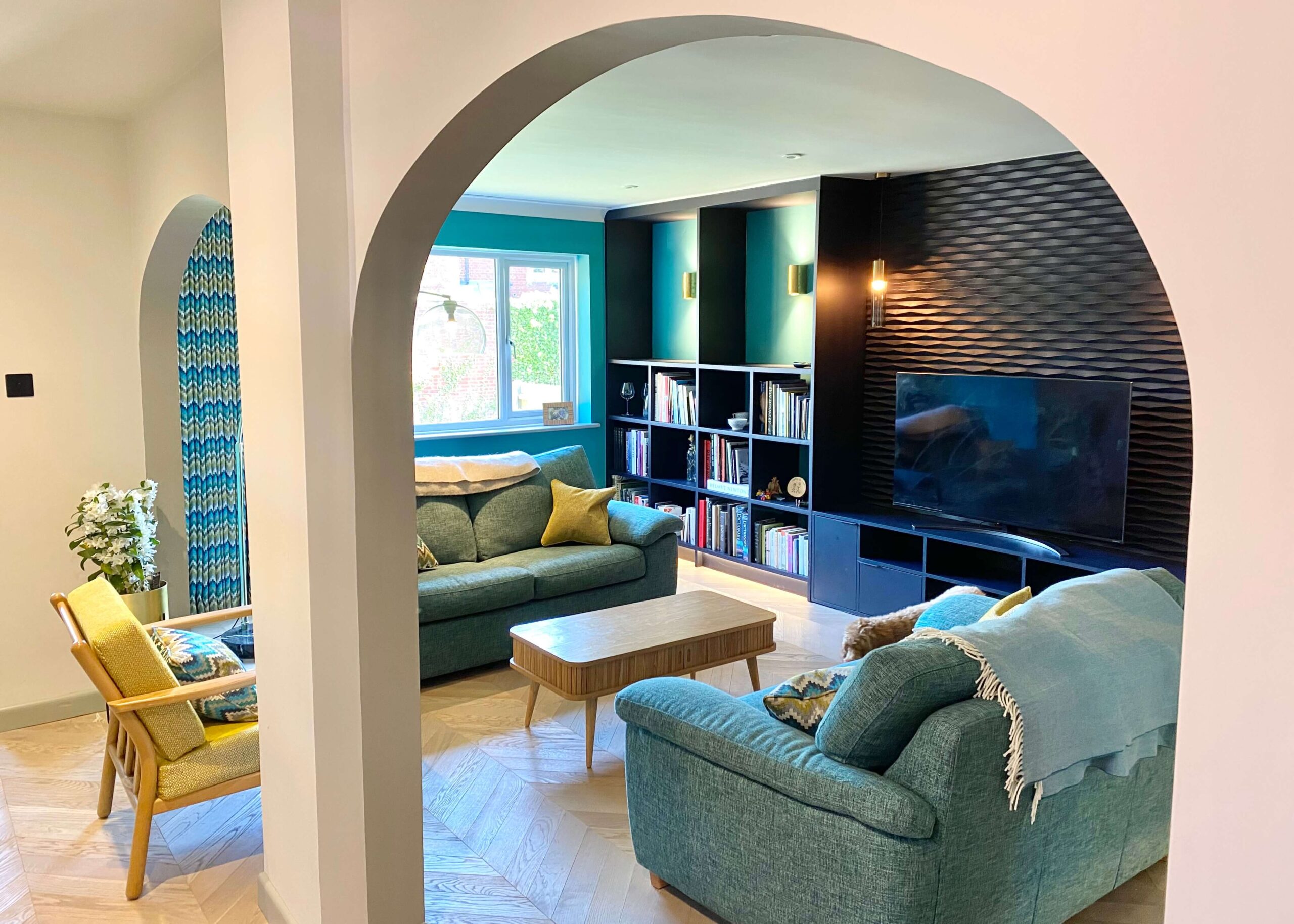 Blue-toned sitting room looking through an arched walkway