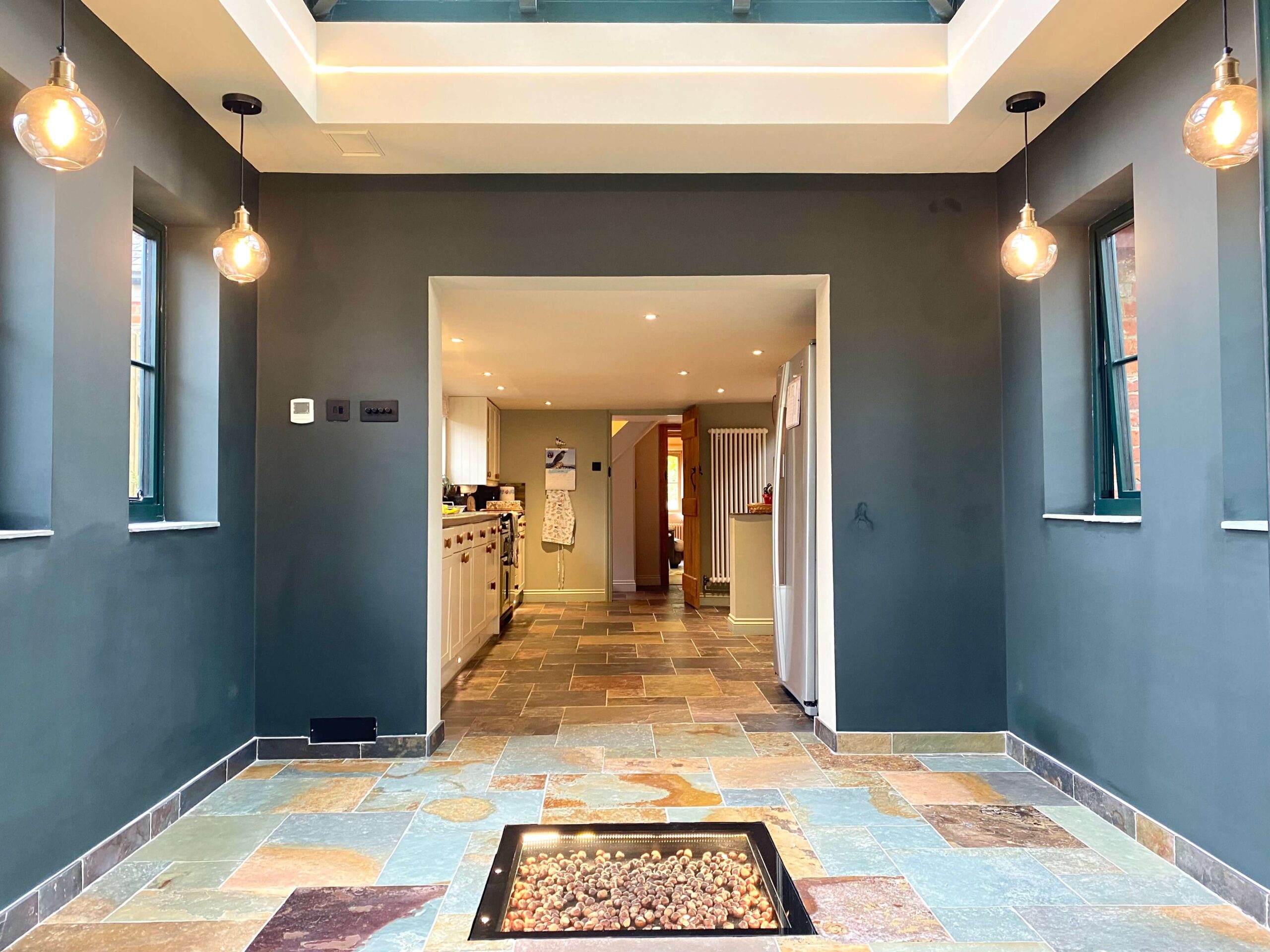 A cottage extension off of the kitchen with stone detailing and blue walls 