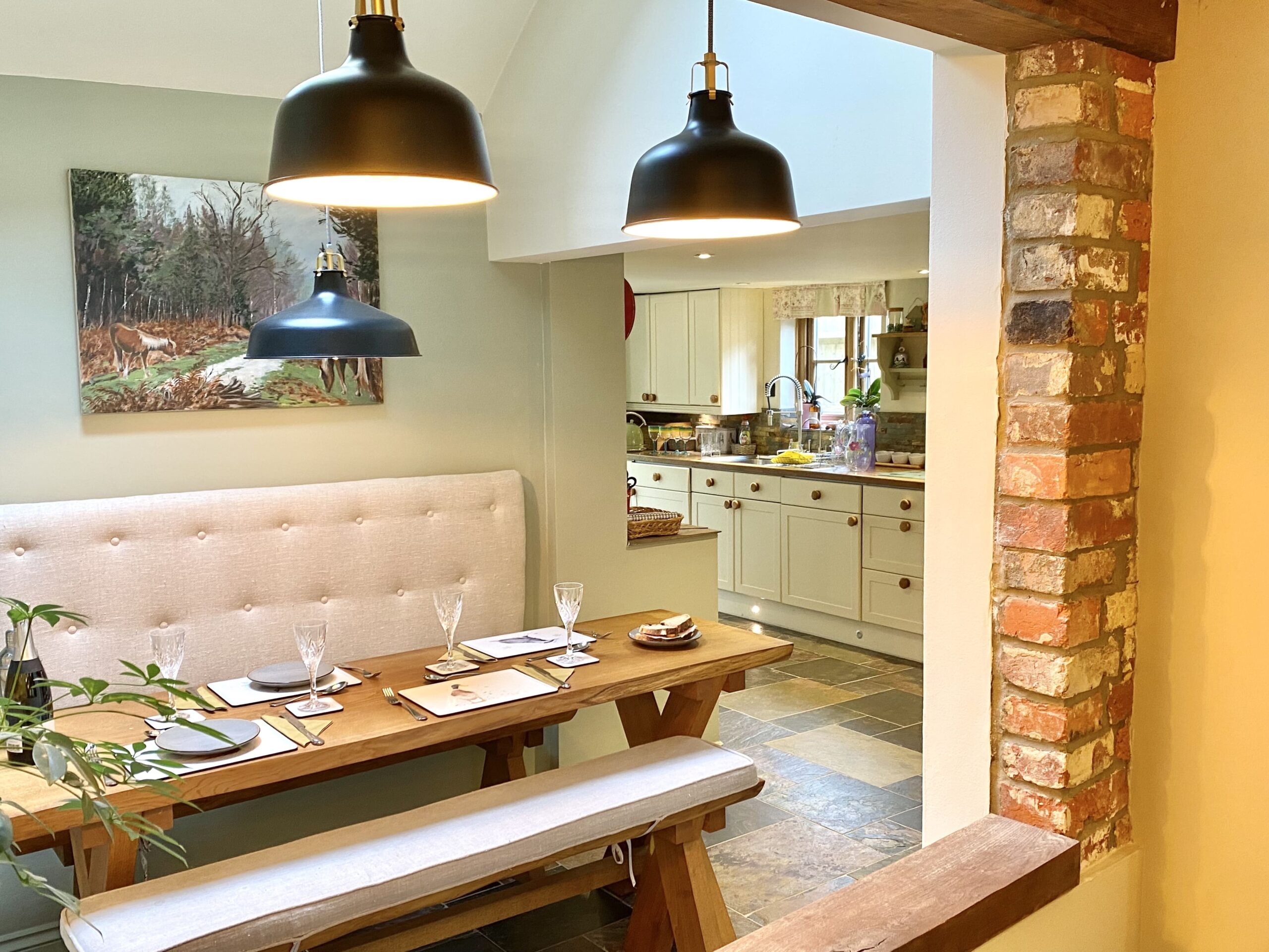 Cottage dining room with bench seat and exposed brick 