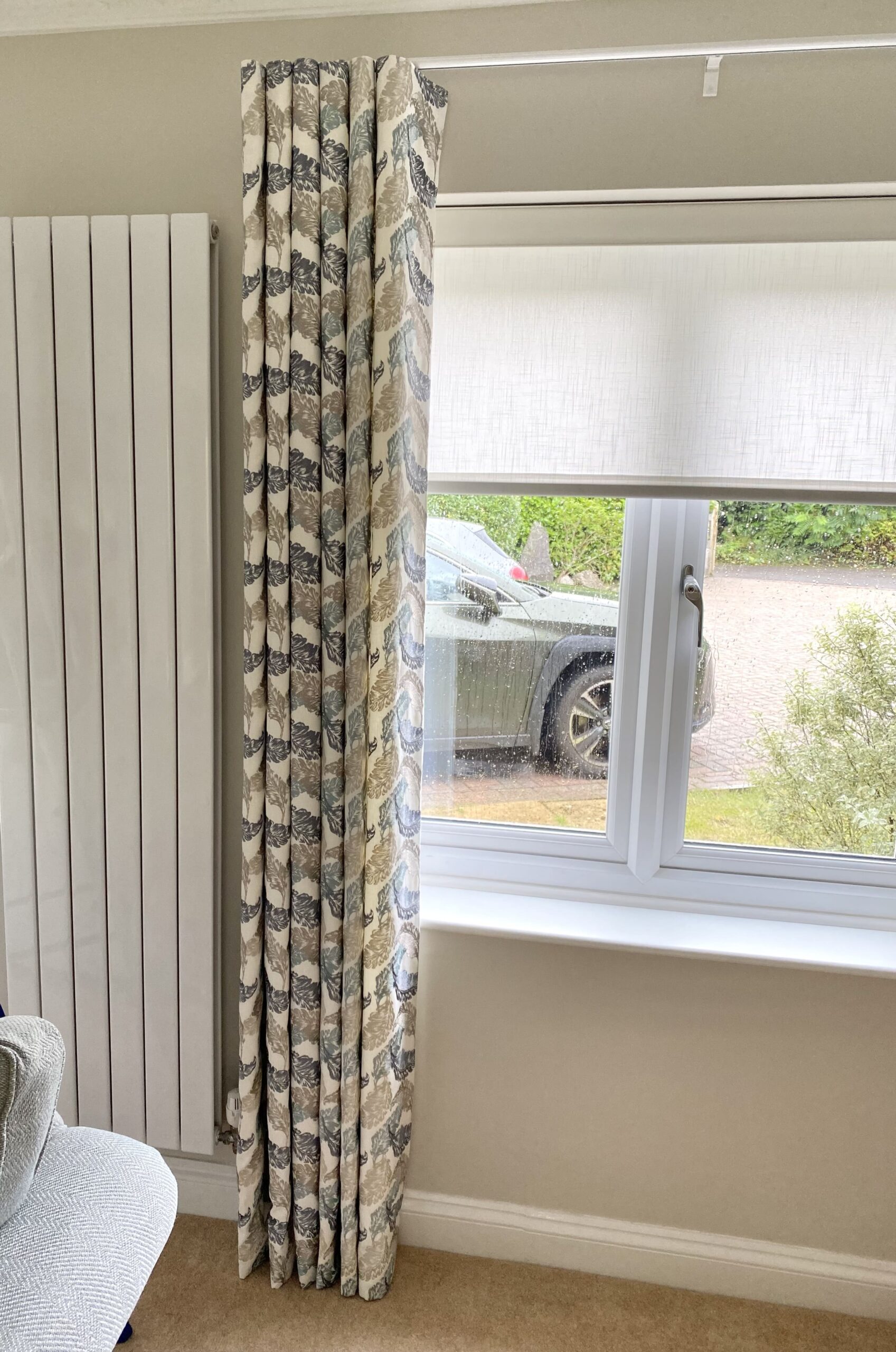 Curtains by a window with a car outside 