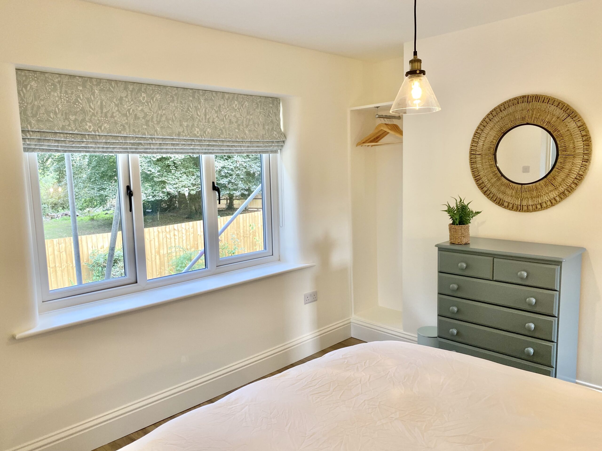 Coastal themed bedroom with mirror and window 