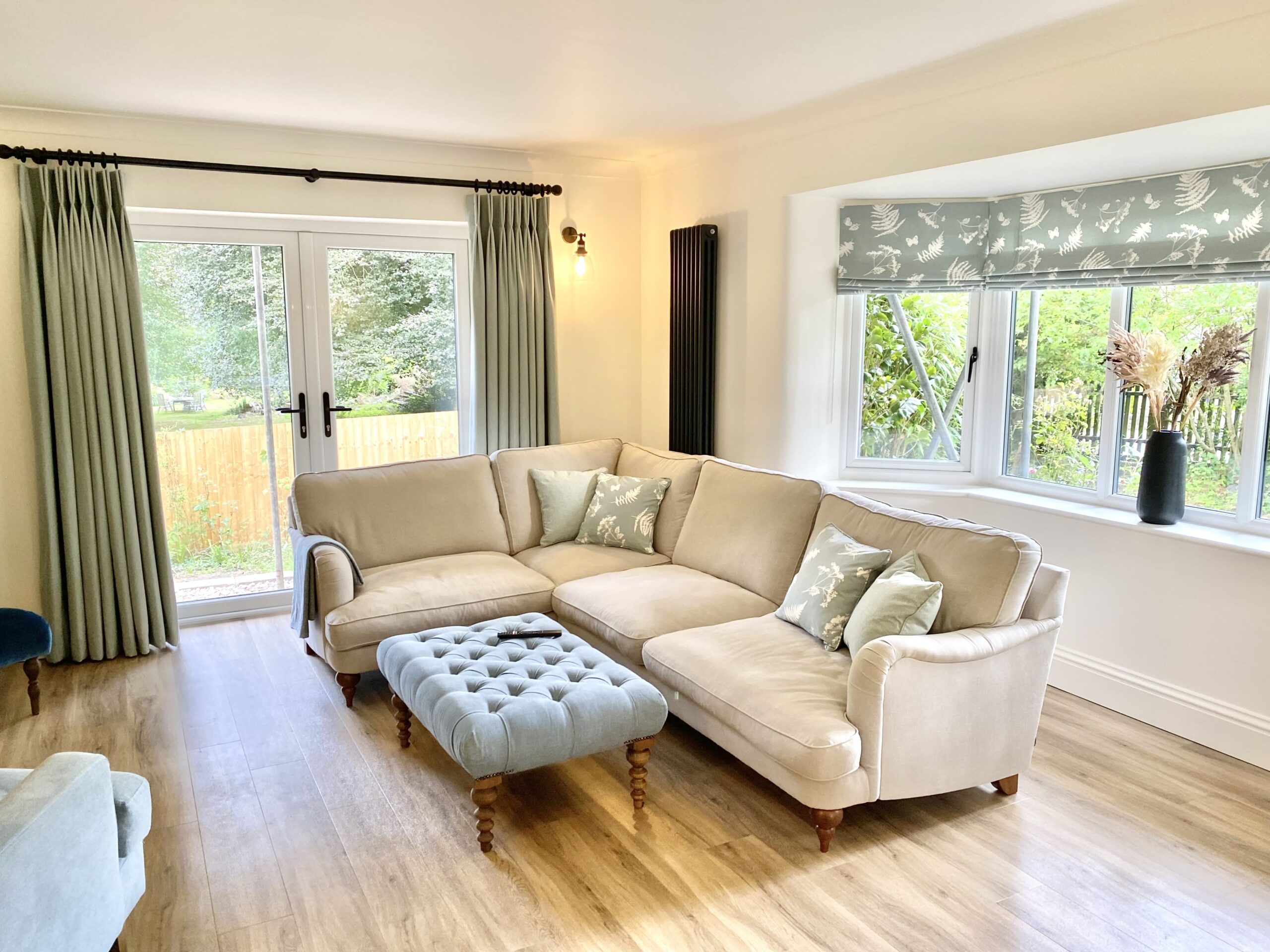 A blue and grey toned sitting room with sofa and ottoman 