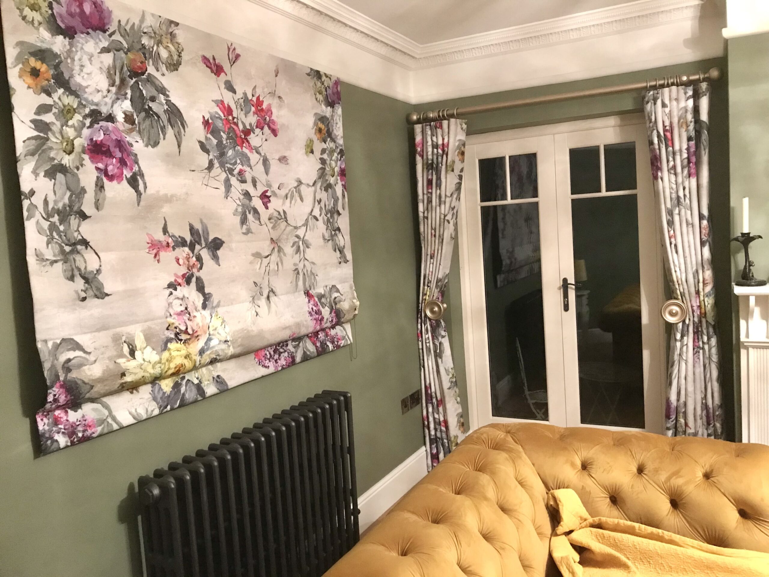 A sitting room with floral blinds and a door