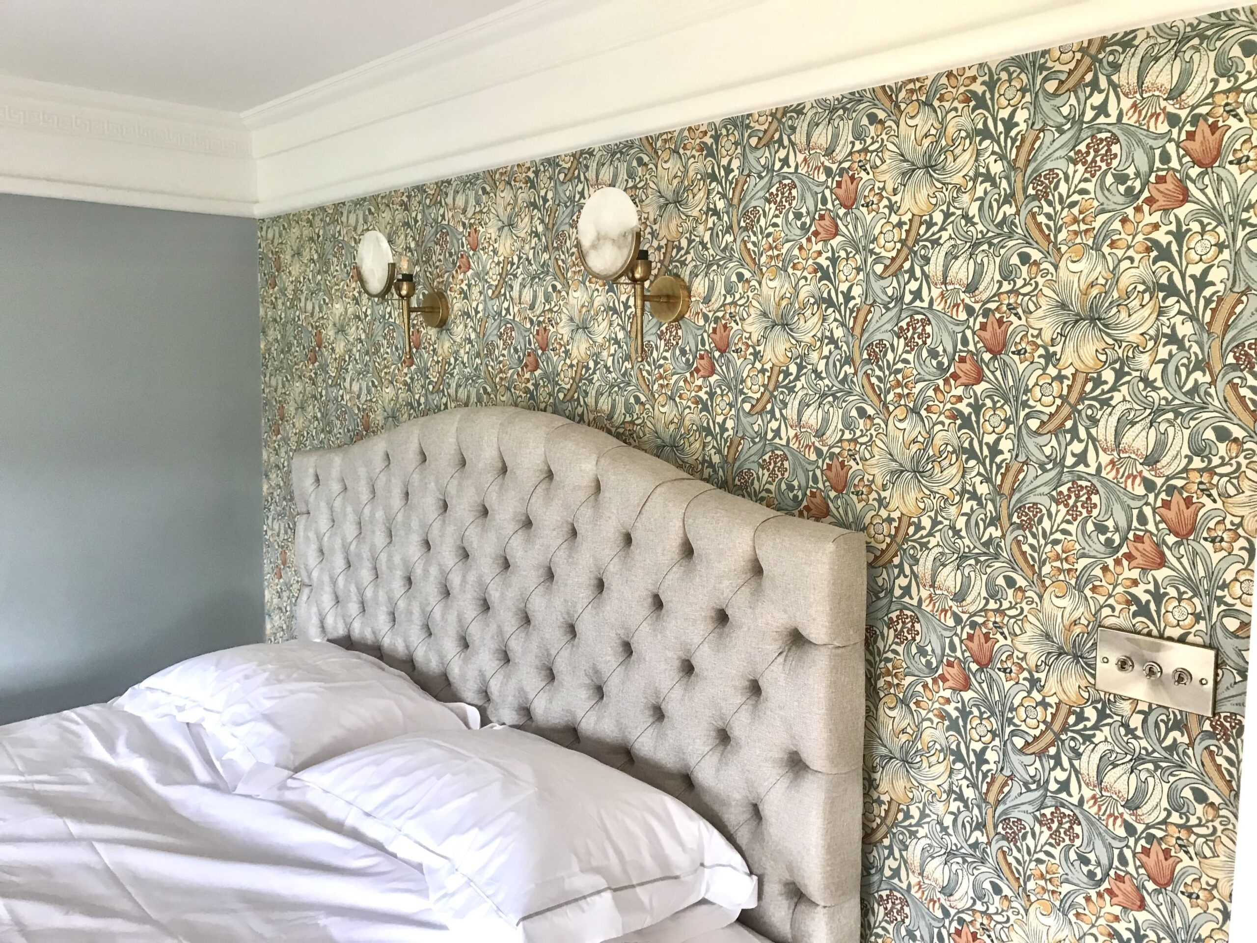 Floral wallpaper and an upholstered headboard 