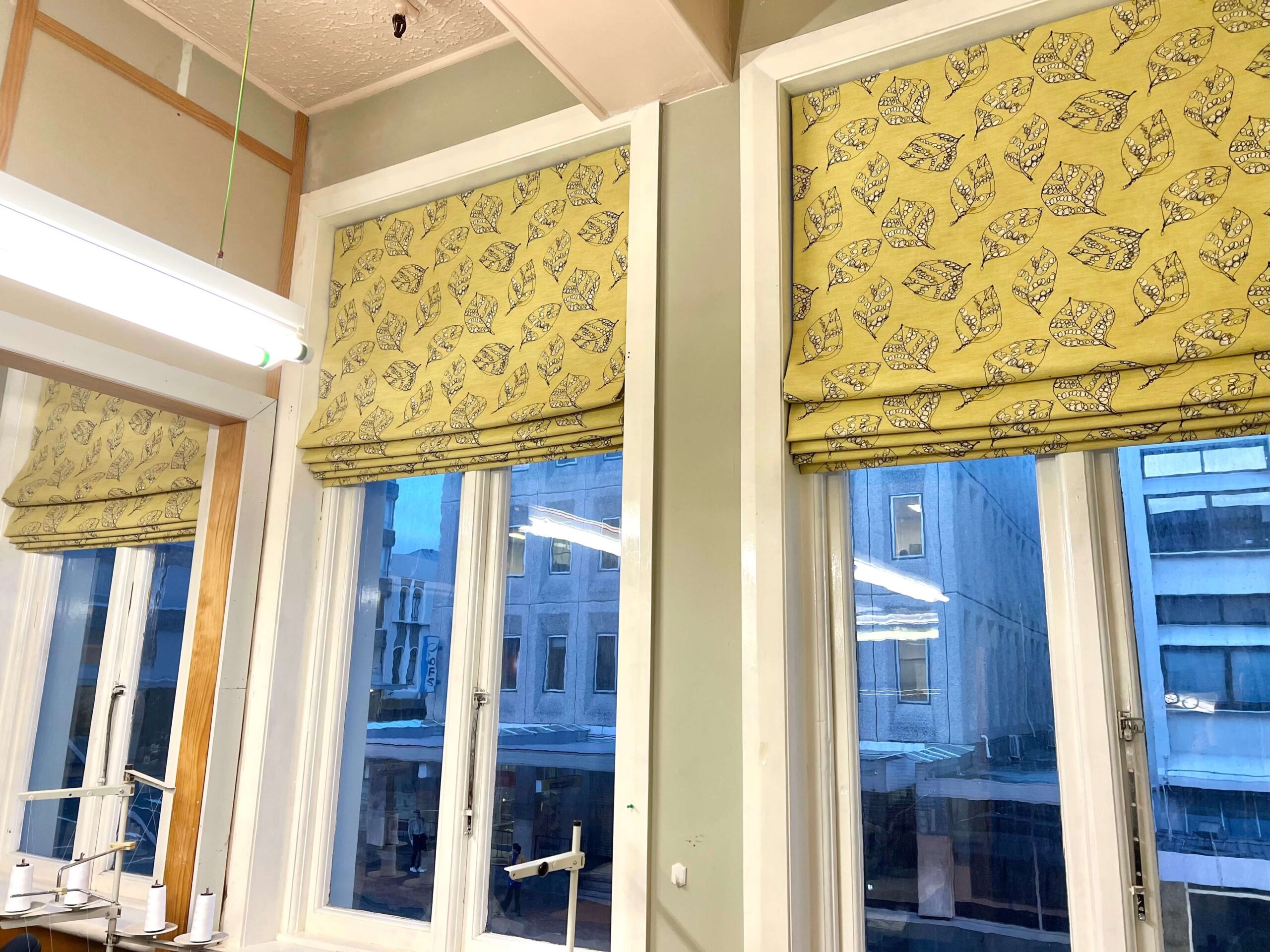 Yellow patterned blinds against a window in a city building